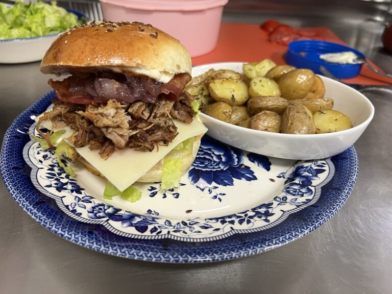 Burger accompagné de pommes de terre dans une assiette.